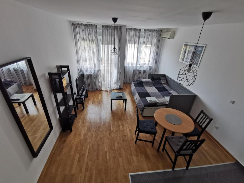 eine Luftansicht auf ein Wohnzimmer mit einem Tisch und Stühlen in der Unterkunft Studio Charlie Aviv Park Zvezdara in Belgrad