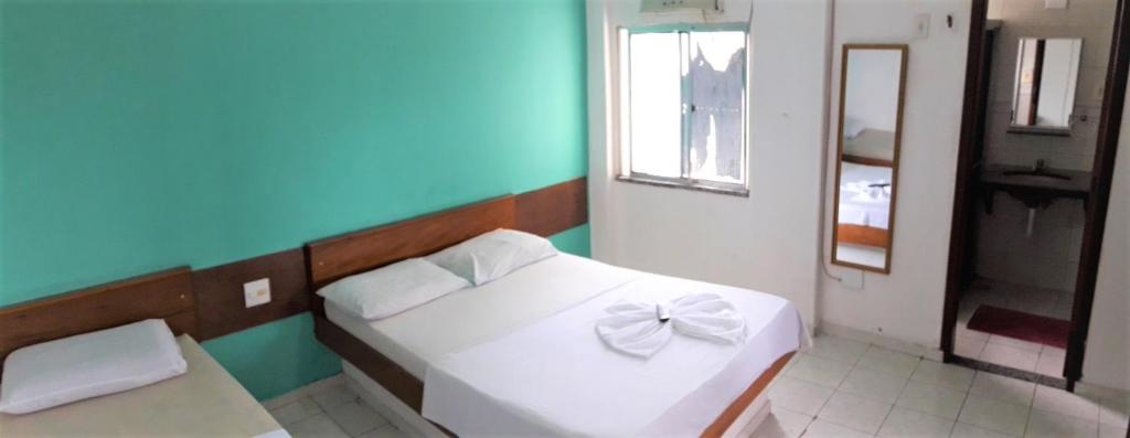 a bedroom with a white bed with a bow on it at Hotel Dez De Julho in Manaus
