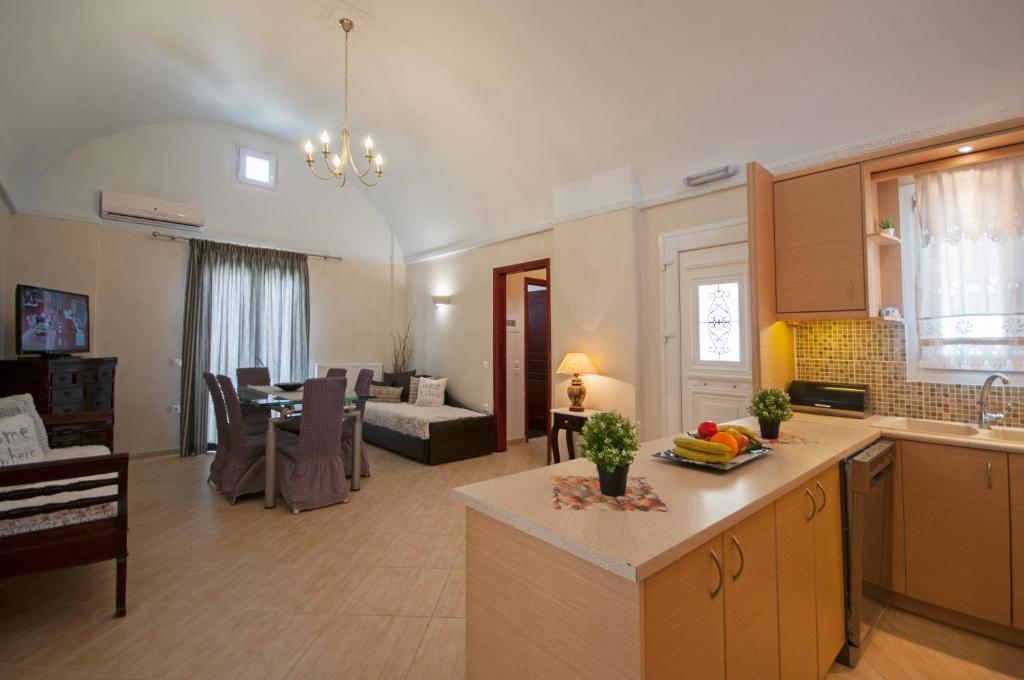 eine Küche und ein Wohnzimmer mit einem Sofa und einem Tisch in der Unterkunft Veldi Art - Kamari Beach Apartment in Fira