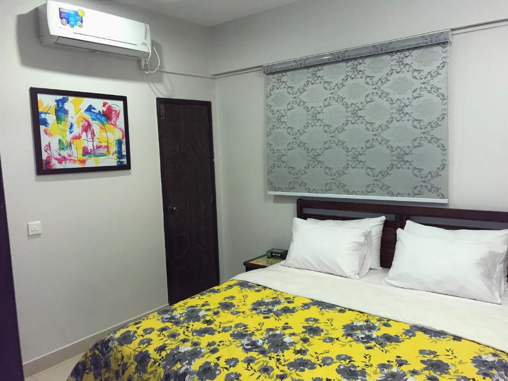 a bedroom with a bed with a yellow blanket at "Service Apartments Karachi" Ocean View 2 Bed Room Apt in Karachi