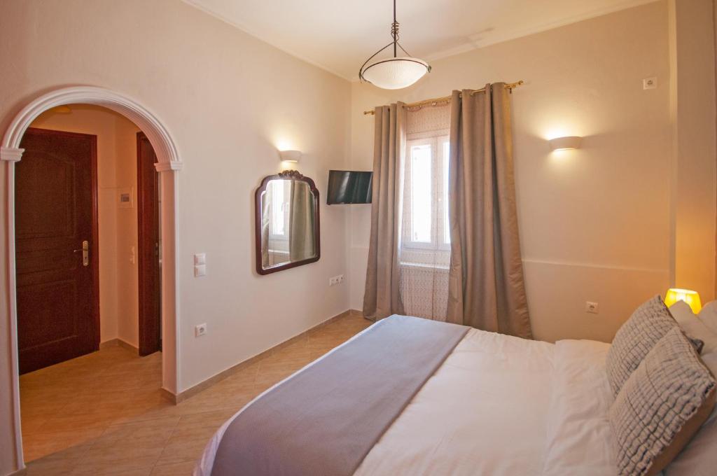 sypialnia z dużym łóżkiem i oknem w obiekcie Veldi Art - Kamari Beach Apartment w Firze
