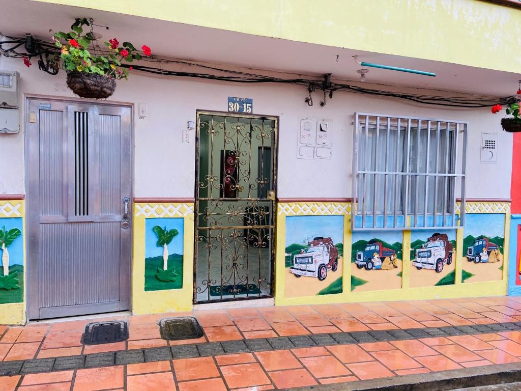 - un bâtiment avec une porte et des peintures dans l'établissement VIVIENDA TURÍSTICA EL ZÓCALO, à Guatapé