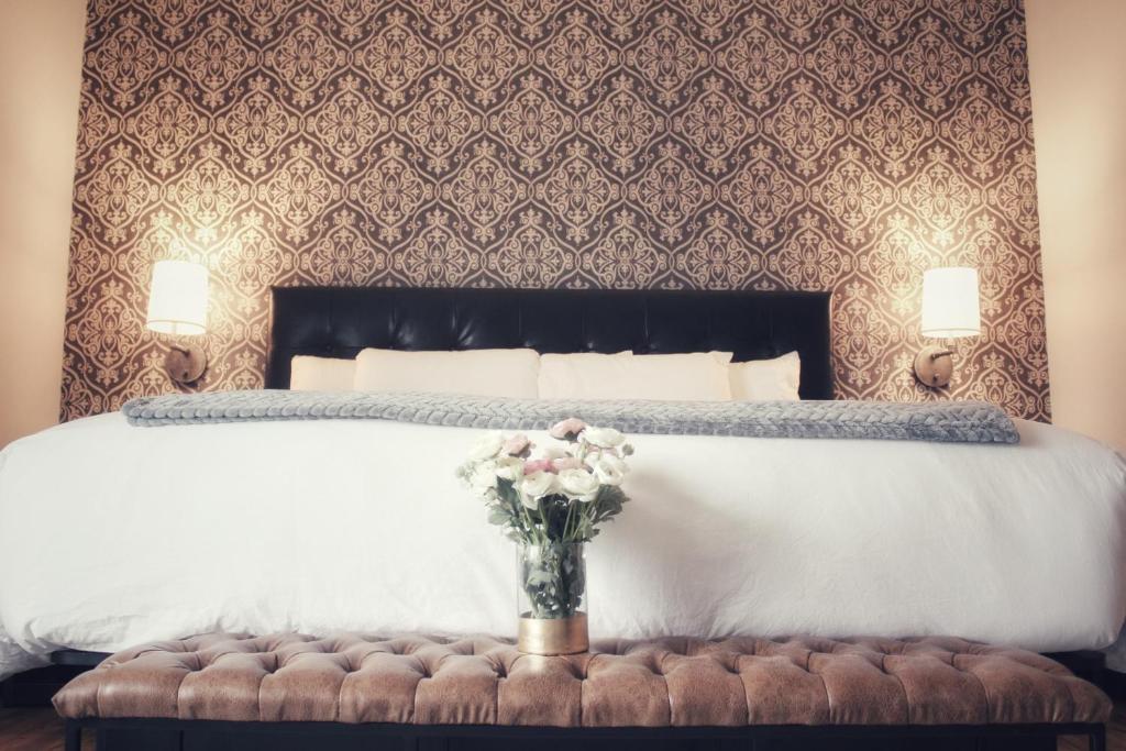 a bedroom with a bed with a vase of flowers on a bench at Waterfront Hotel in Prairie du Chien