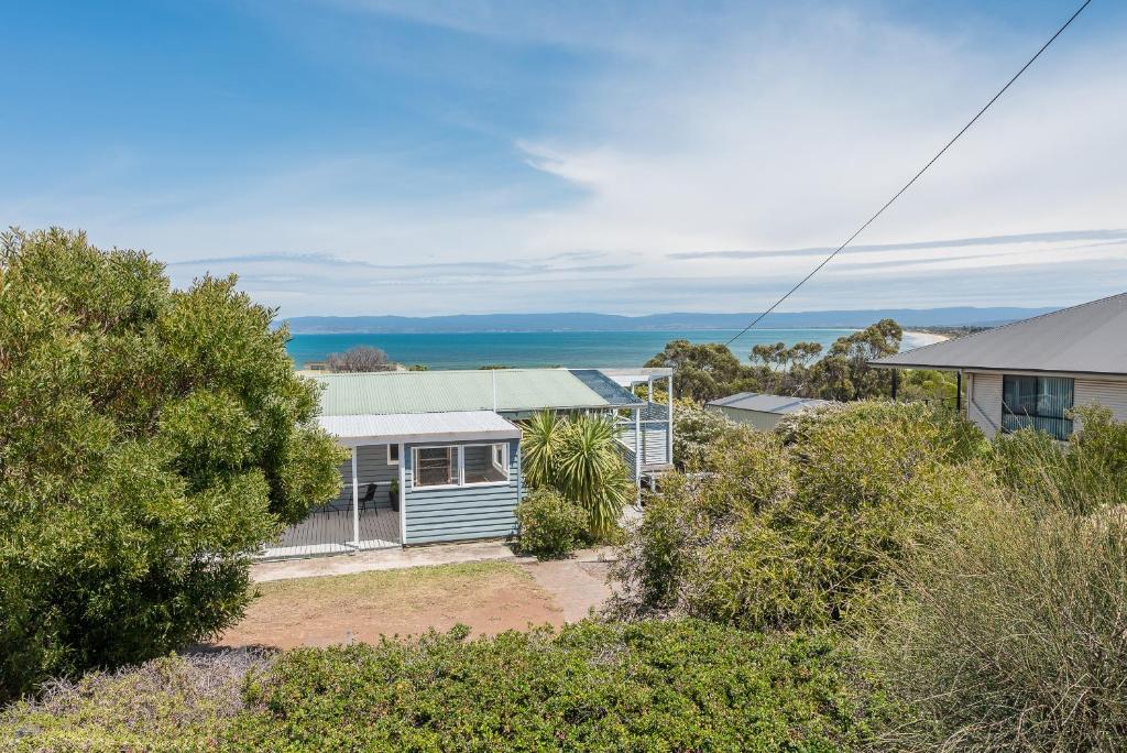 an aerial view of a house with the ocean in the background at Acacia Cottage in Coles Bay