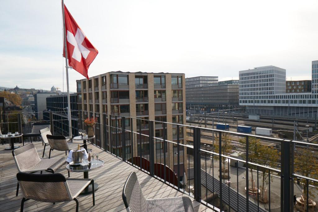 uma varanda com uma mesa e cadeiras e uma bandeira canadiana em Boutique Hotel Josef em Zurique