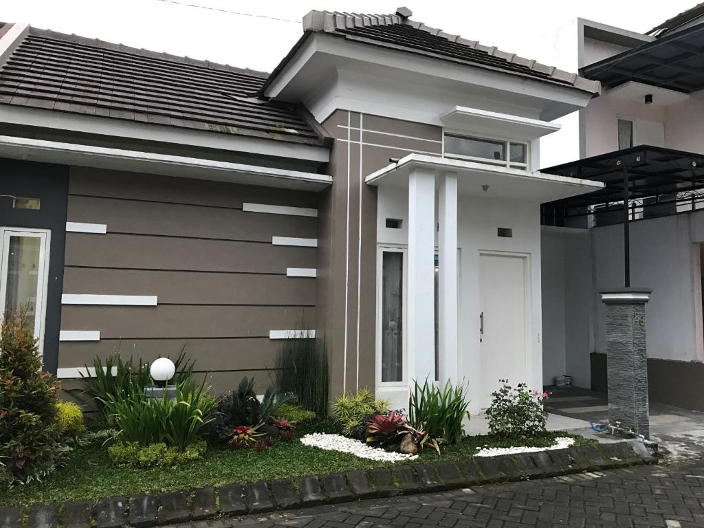 ein Haus mit einer weißen Tür und einigen Pflanzen in der Unterkunft Villa Mutiara Batu in Batu