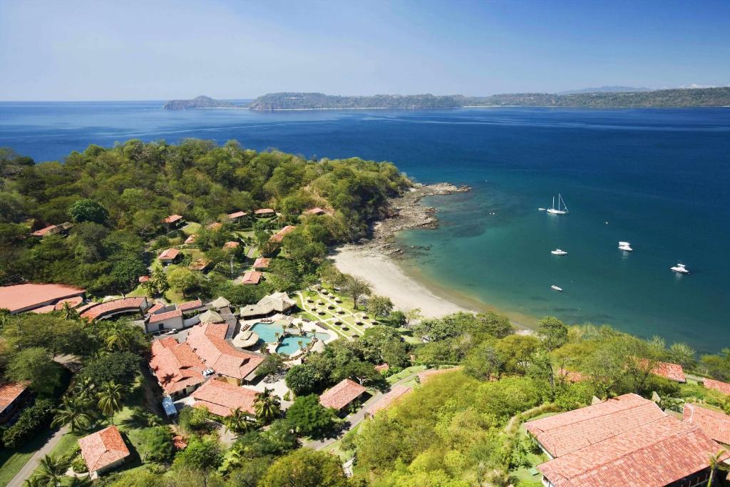 an aerial view of a resort with boats in the water at Secrets Papagayo All Inclusive - Adults Only in Papagayo, Guanacaste