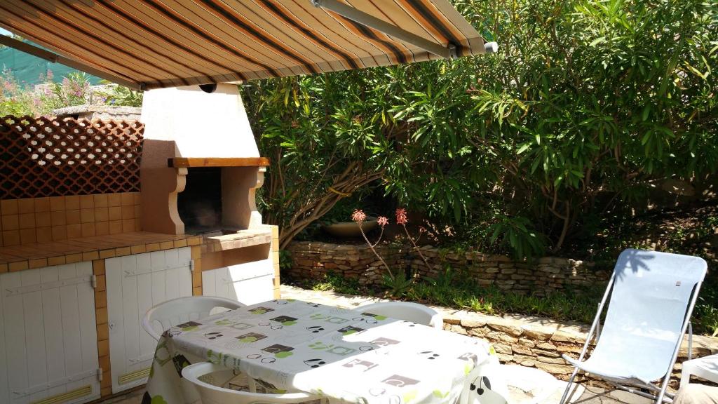 une table et des chaises assises sous un toit dans l'établissement Mas de l île rousse, à Bandol