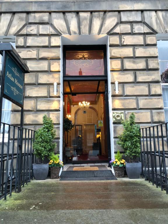 un ingresso a un edificio con due piante in vaso di Atlas Guest House a Edimburgo