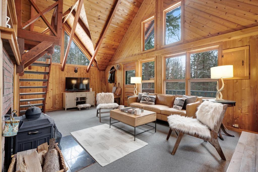 a living room with a couch and a tv in a cabin at Vermont Chalet in Wilmington