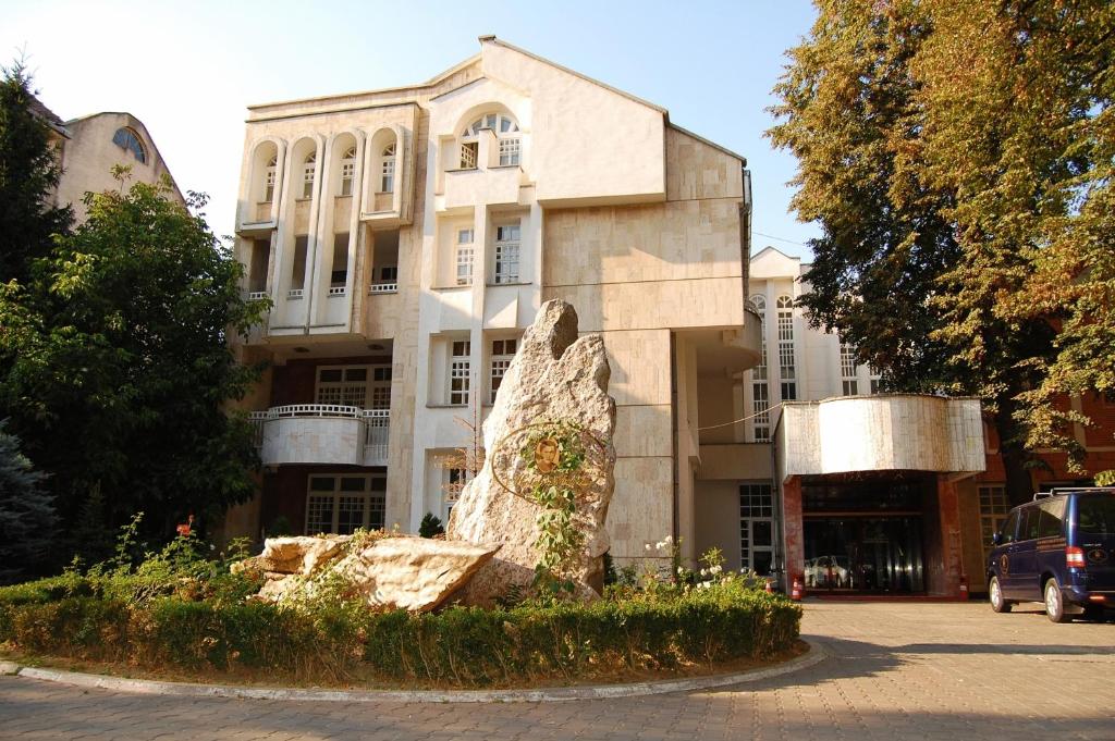 a building with a statue in front of it at Hotel Maria in Botoşani