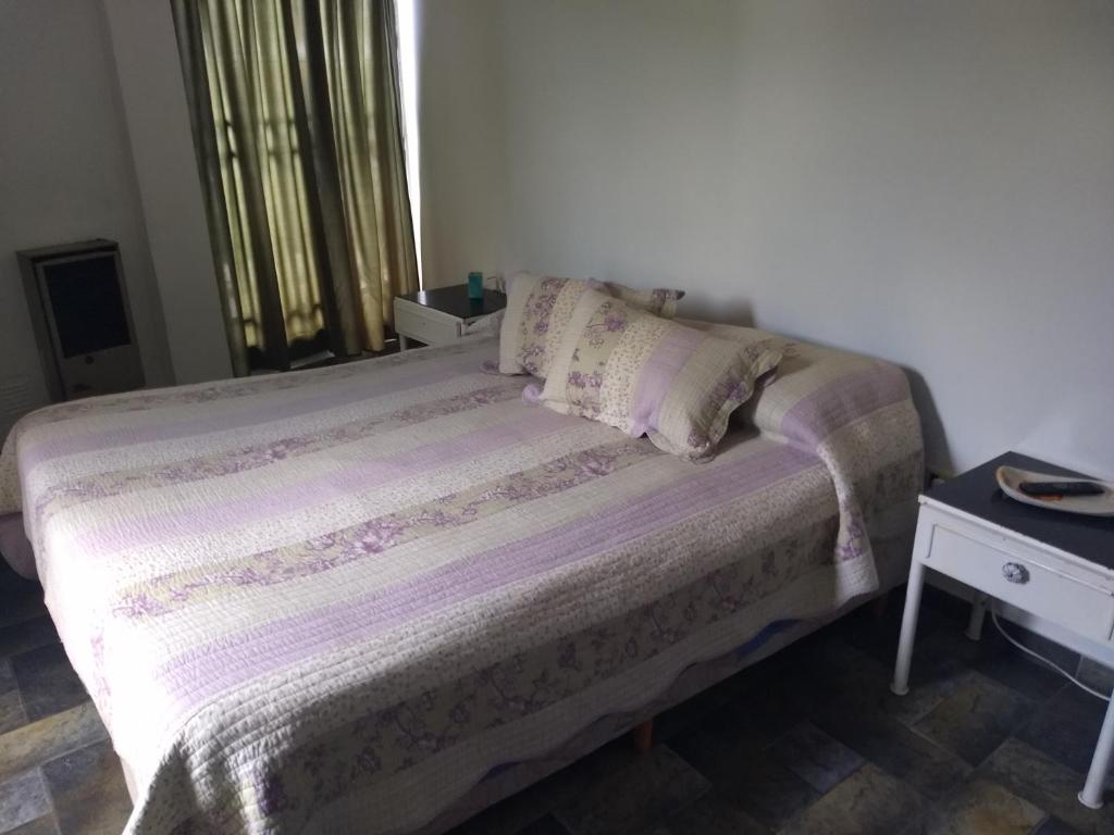 1 cama en un dormitorio con ventana y mesa en Alojamiento Entero con Excelente Ubicación en Morón