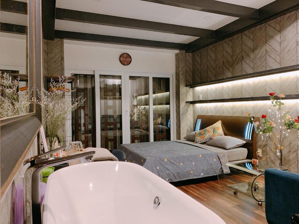 ein Bad mit Badewanne und ein Bett in einem Zimmer in der Unterkunft Luxurious Chinatown Hideaway in Ho-Chi-Minh-Stadt