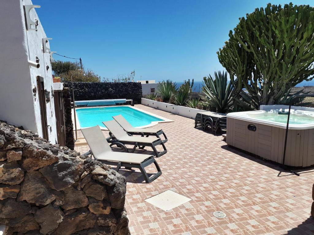 a swimming pool with two lounge chairs and a hot tub at Casa Tara - 5 bedroom, 4 bathroom villa with private pool in Mácher