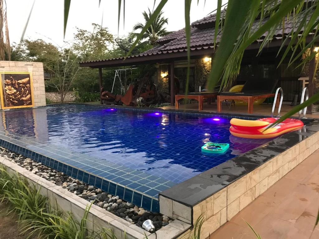 a swimming pool with an inflatables in front of a house at Rock Garden E28 Pool villa in Mae Pim