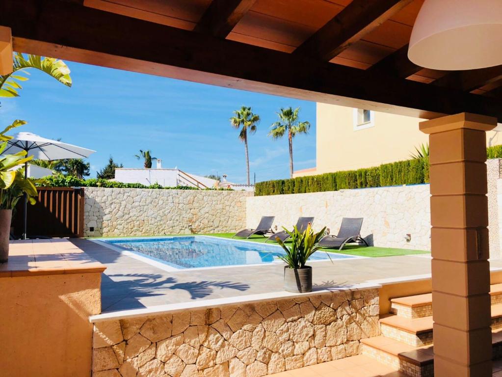 eine Terrasse mit Pool und ein Haus in der Unterkunft Villas2meet in Cala Romantica