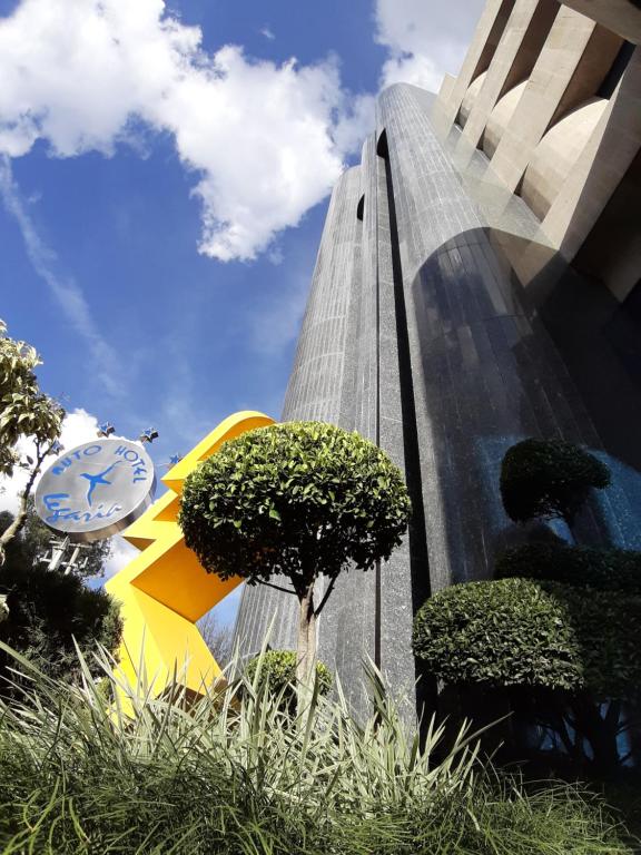 Un edificio alto con un reloj a un lado. en AUTO HOTEL LEGARIA, en Ciudad de México