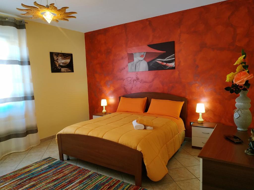 ein Schlafzimmer mit einem Bett mit einer orangefarbenen Wand in der Unterkunft B&B Salerno in Sarno