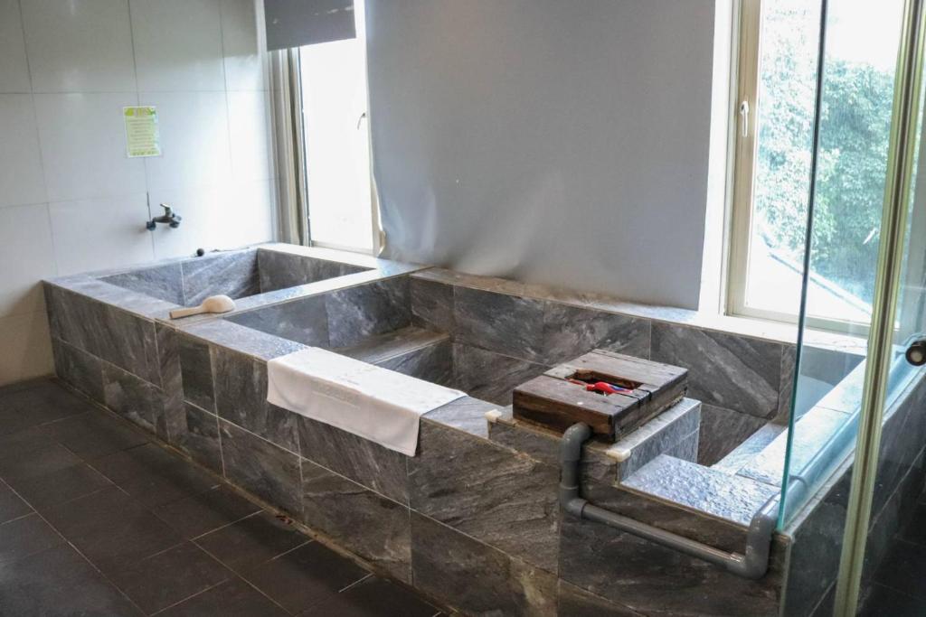 a bathroom with a stone tub with a window at The Loft Seaside Suites in Jinshan