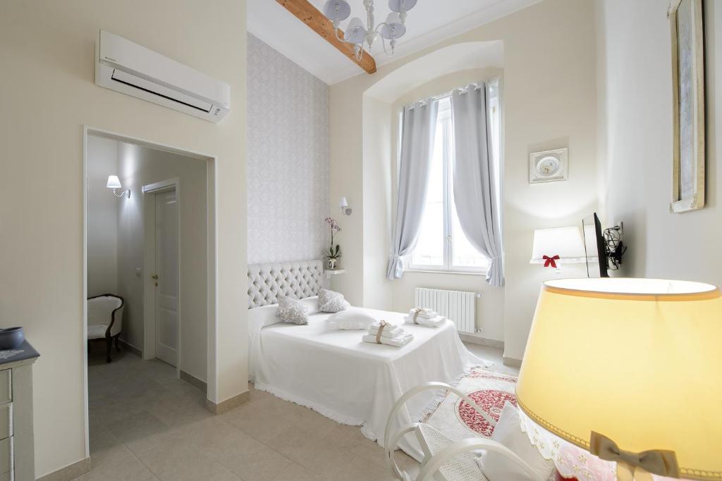 a white bedroom with a bed and a window at Milcovich Suites in Barletta