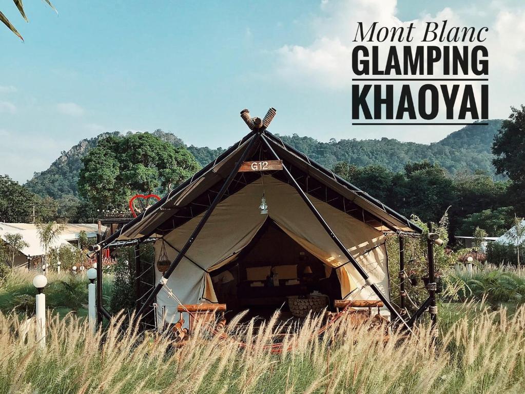 ein Zelt auf einem hohen Gras mit den Worten mont blanc camping Kingdom in der Unterkunft Mont Blanc Glamping Khao Yai in Mu Si