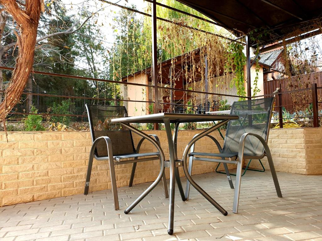 - une table et deux chaises sur la terrasse dans l'établissement Slovac House with a garden and fireplace, à Chişinău