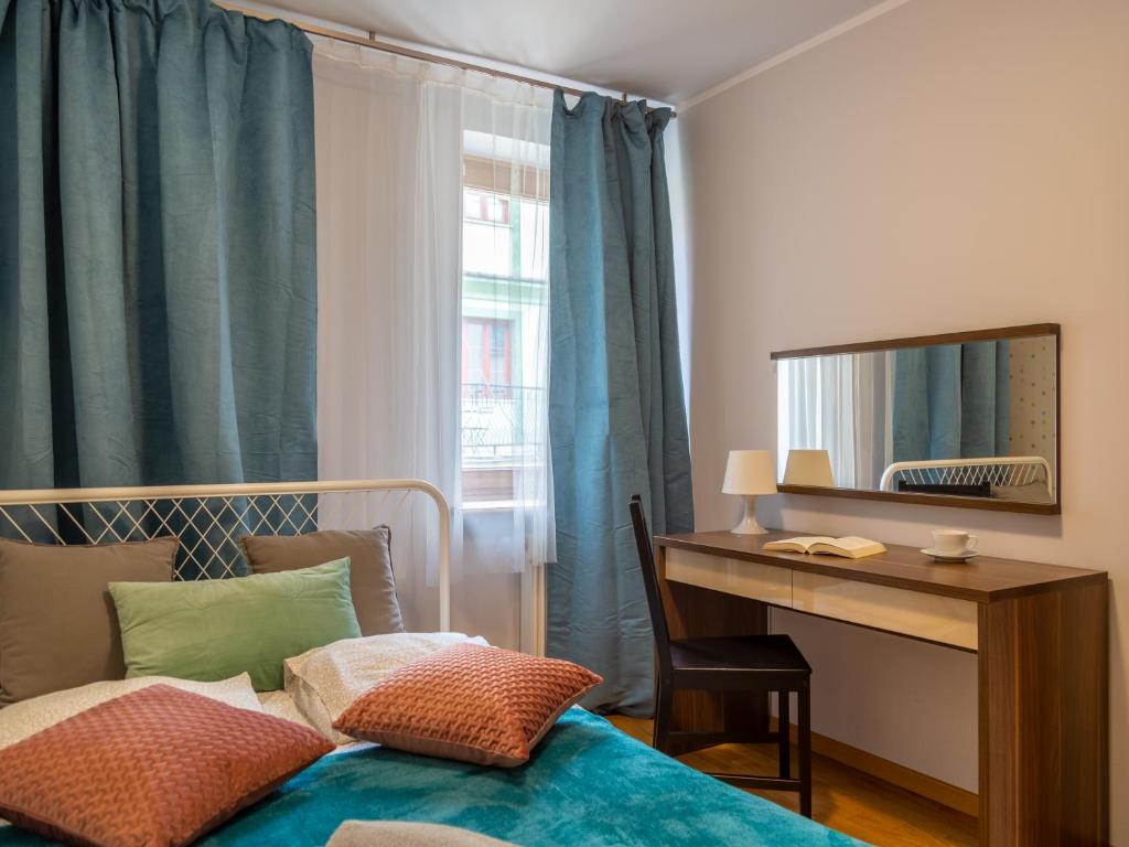 a bedroom with a bed and a desk and a mirror at Nozownicza Street Apartment in Wrocław