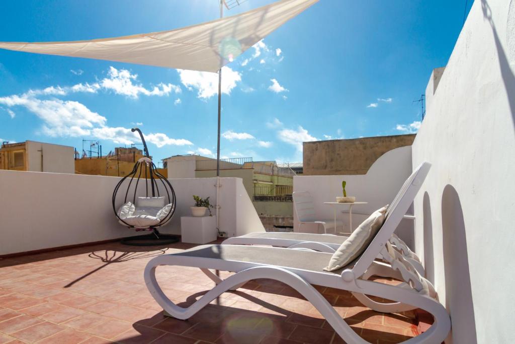 une chaise blanche et un parasol sur le toit dans l'établissement Casa Doña Carmela GuestHouse - Adults Only, à Santa Cruz de Tenerife