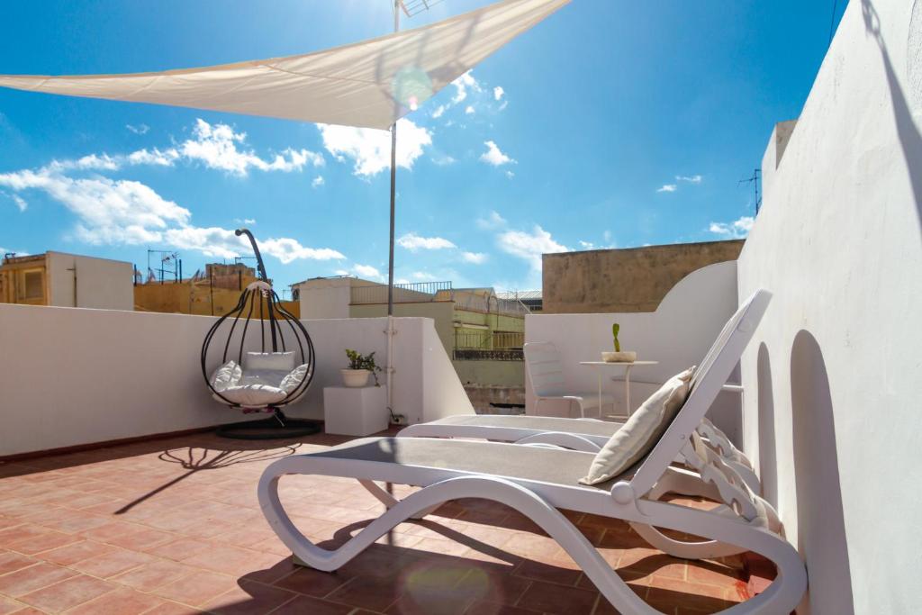 een witte stoel en een paraplu op een dak bij Casa Doña Carmela GuestHouse - Adults Only in Santa Cruz de Tenerife