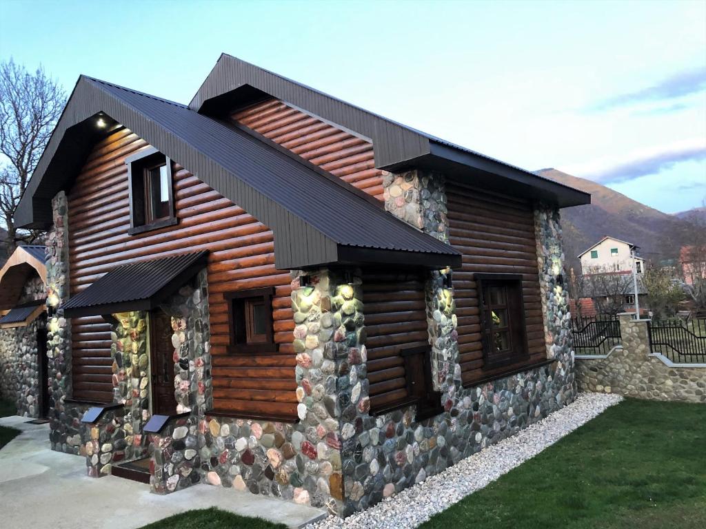 a log cabin with a black roof at Stone Lodge 2 in Kolašin