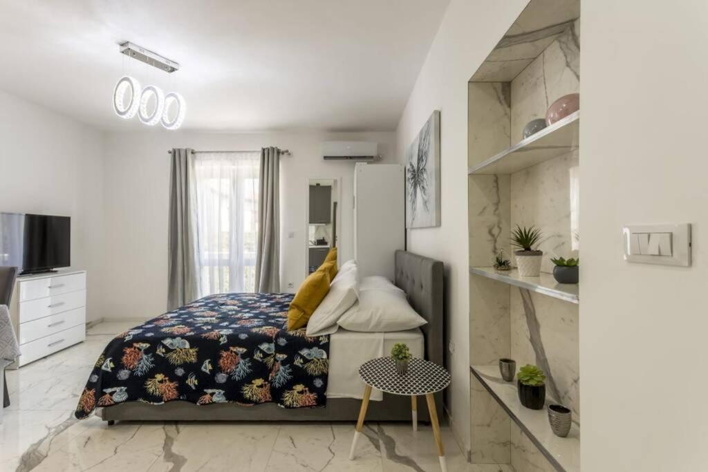 a bedroom with a bed and a table in it at Royal Platinum Studio Apartment in Vodice