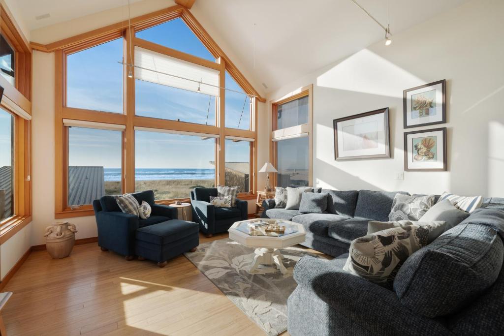 a living room with a blue couch and chairs at Sanderling by the Sea in Westport