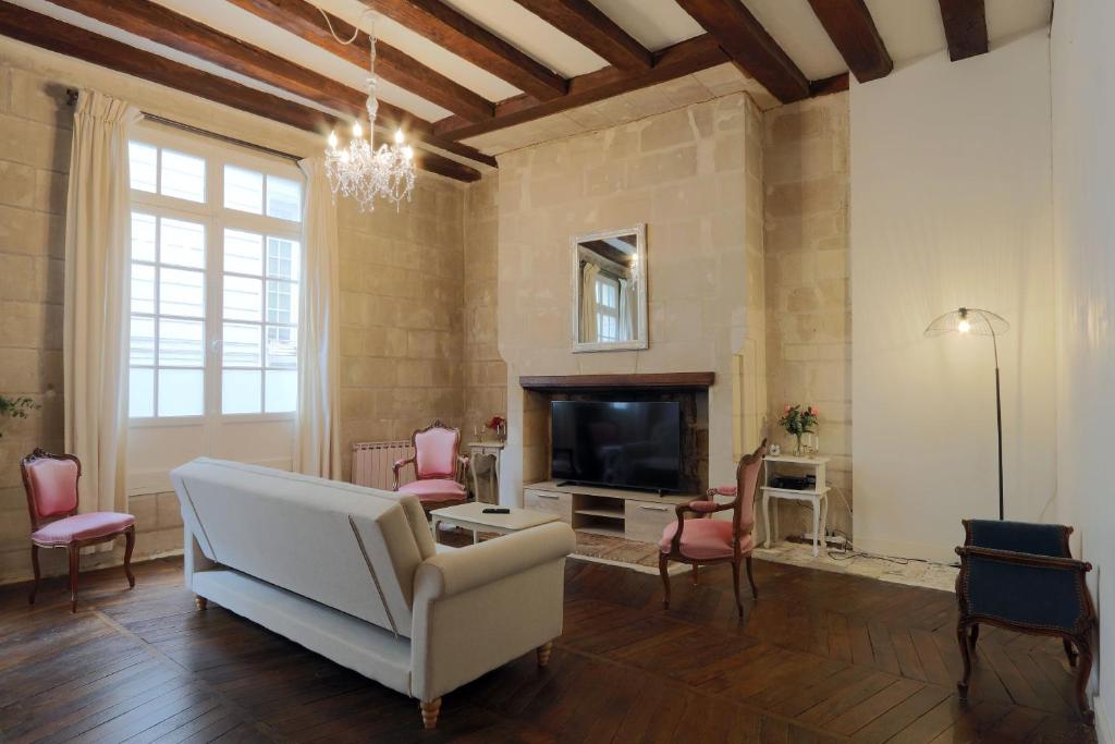 a living room with a white couch and a fireplace at charme d'ancien au coeur de vieux-tours in Tours