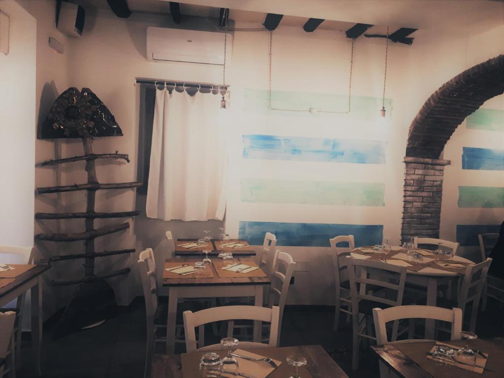 a dining room with tables and chairs and a window at Locanda del Sole Nero in San Terenzo