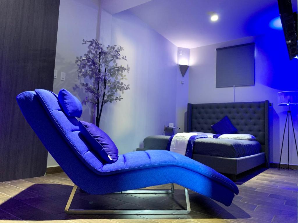 una camera con una sedia reclinabile blu e un letto di Modern Suite #1 Pasavento ad Aguadilla