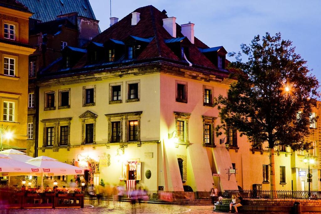 a large white building with a black roof at Castle Inn in Warsaw