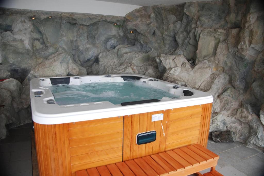 a jacuzzi tub in front of a stone wall at Naturpark-.Weinbergferienhaus in Kitzeck im Sausal