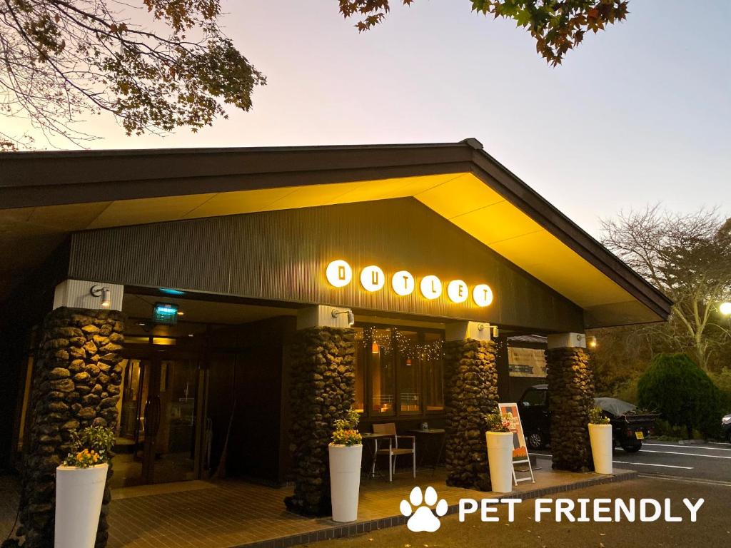 a pet friendly building with a sign in front of it at Sora Hotel Karuizawa Outlet in Karuizawa