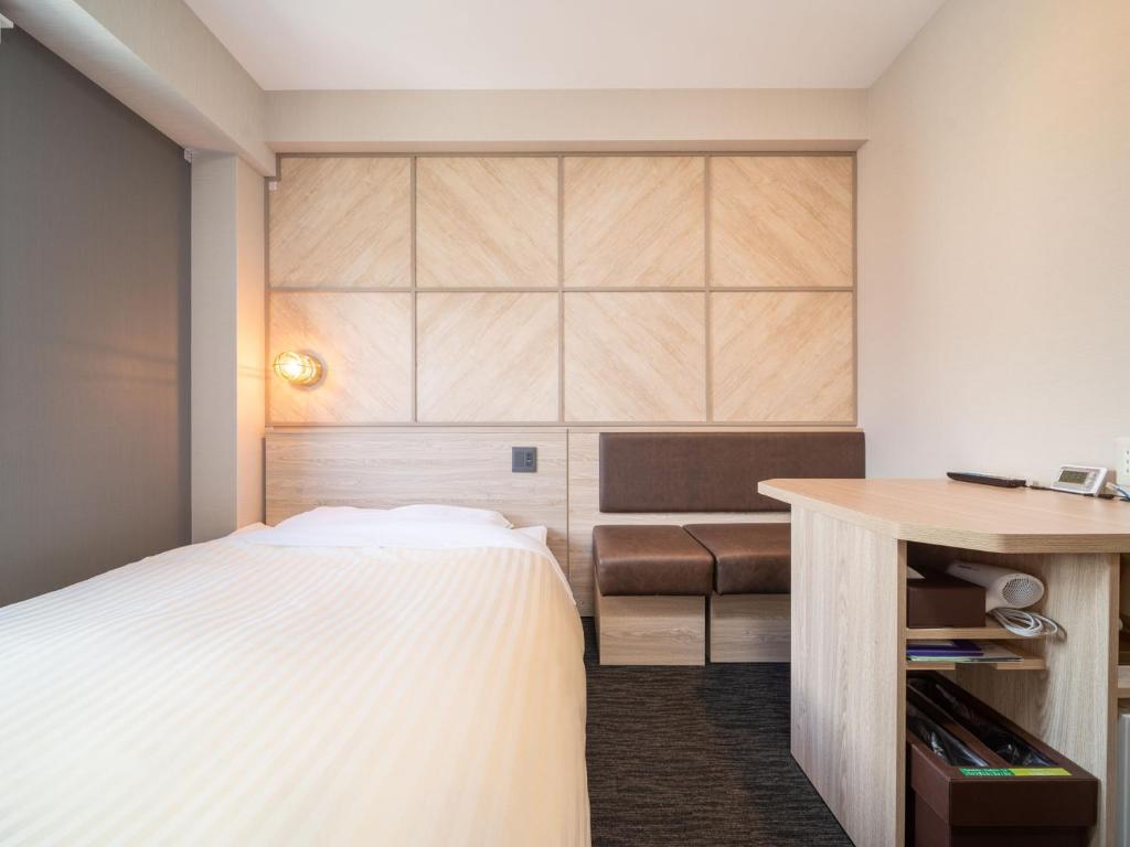 Een bed of bedden in een kamer bij Super Hotel Matsumoto Tennenonsen