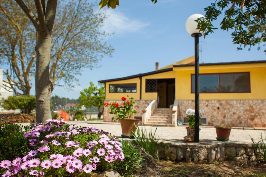 a yellow building with flowers and a street light at Villa Marida in Gioia del Colle
