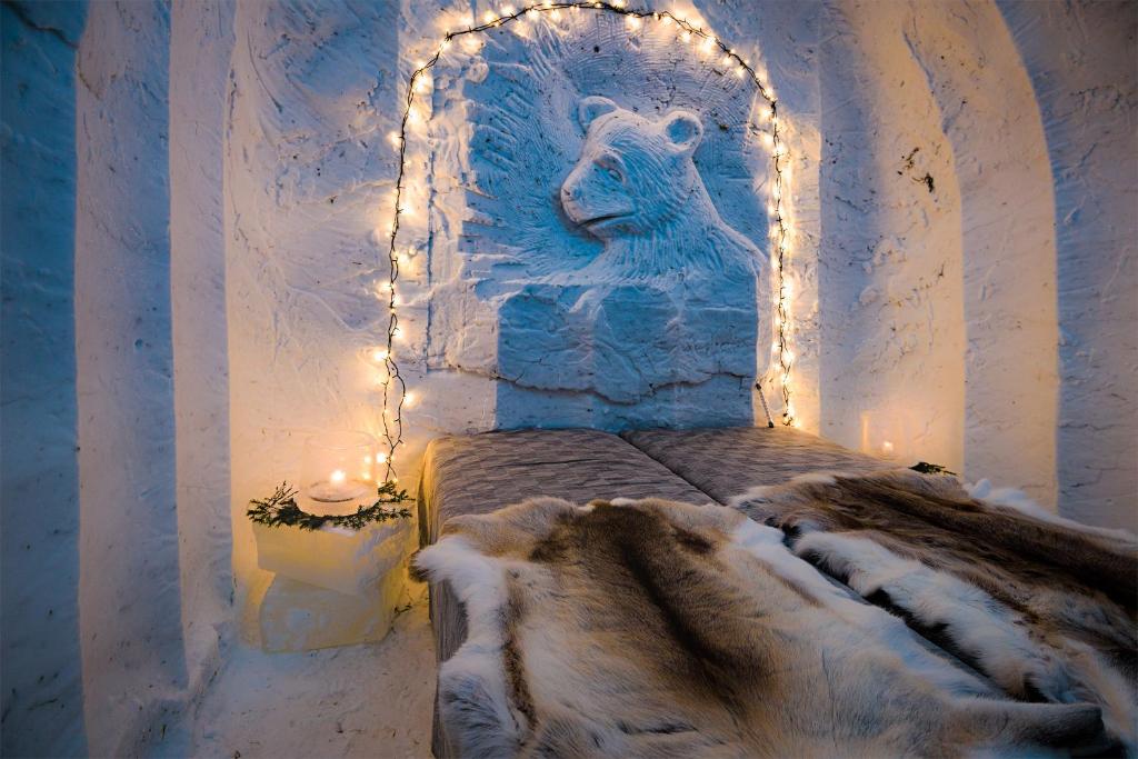 Una habitación con una cama con una estatua de un oso en Lucky Ranch Snow Igloos, en Pyhätunturi