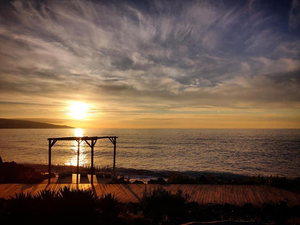 een zonsondergang op het strand met de zon die ondergaat boven de oceaan bij Beach & Surf in Ribeira Grande