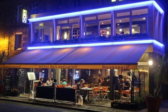 un restaurant avec des personnes assises à l'extérieur la nuit dans l'établissement Rest'à Flots, à Tréguier