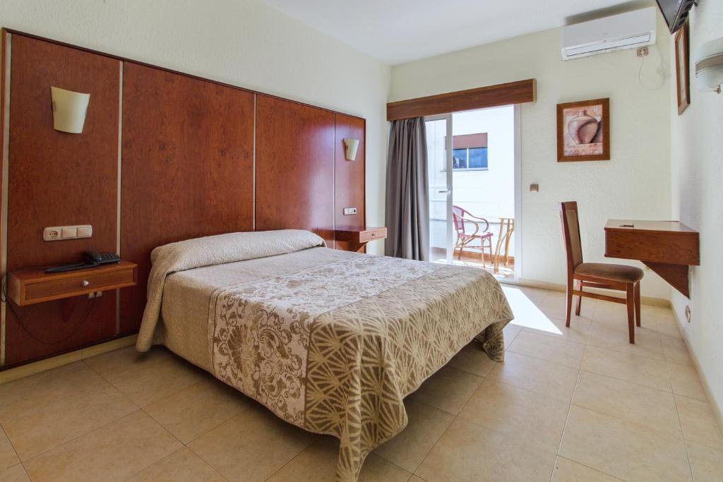 1 dormitorio con 1 cama, 1 mesa y 1 silla en N.Ch, en Torremolinos