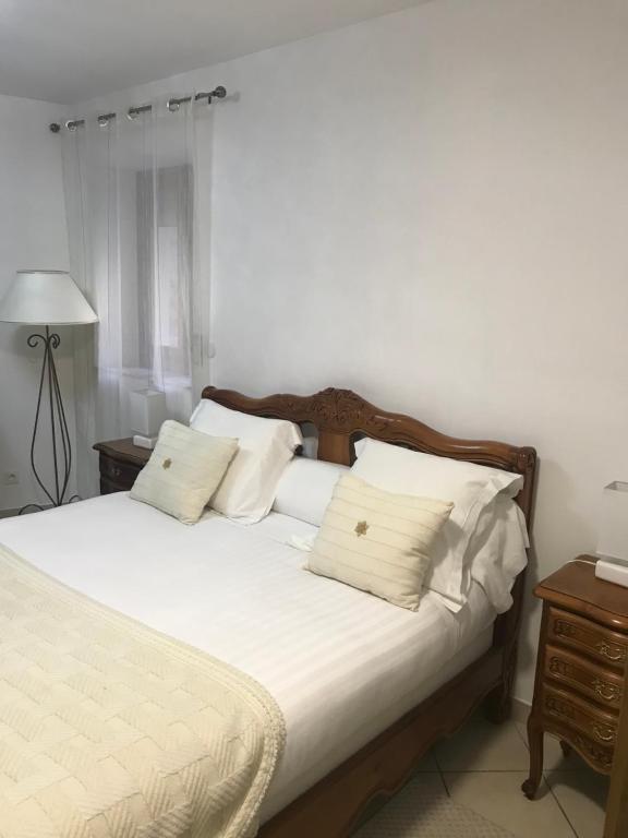 - une chambre avec un lit doté de draps et d'oreillers blancs dans l'établissement Chambre du couvent, à Narbonne