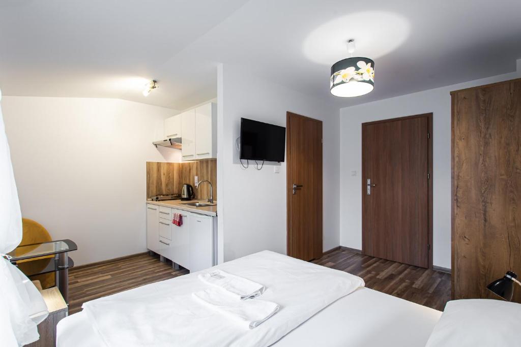 a hotel room with two beds and a kitchen at Pokoje Gold Centrum in Koszalin