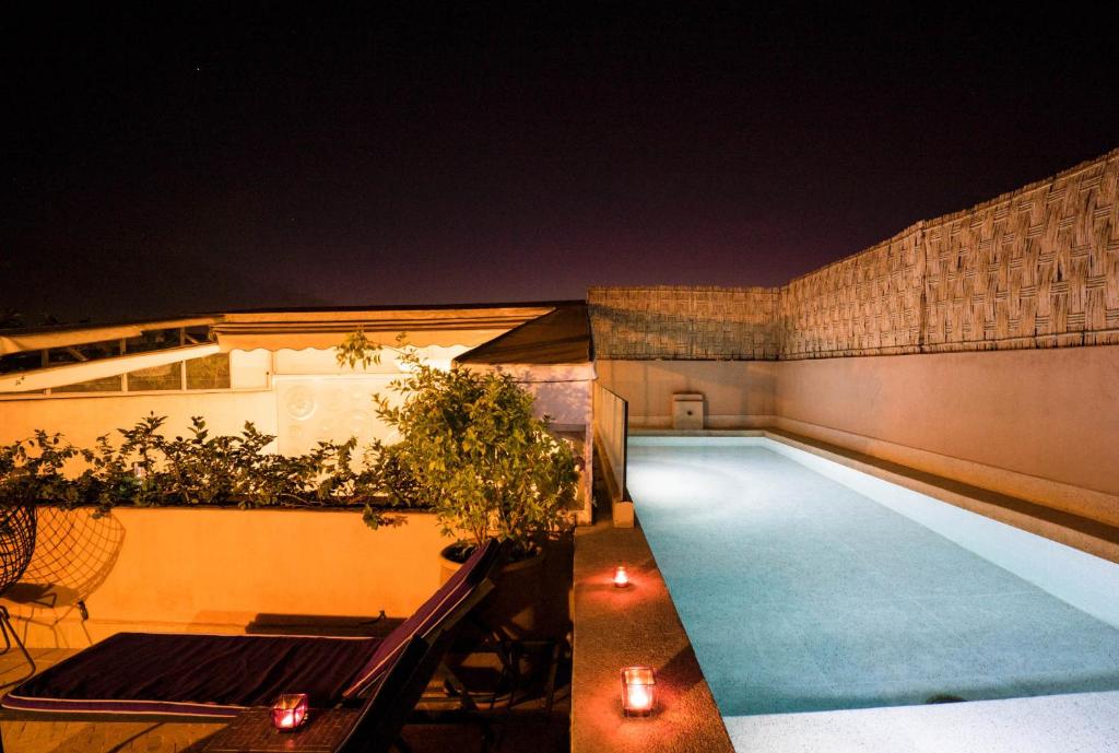 馬拉喀什的住宿－里亞德豪杜賓館，夜间游泳池,有灯光和蜡烛