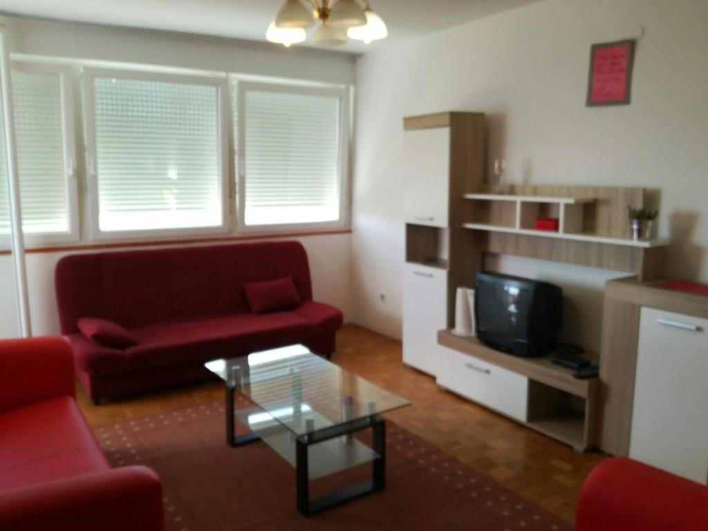 a living room with a red couch and a coffee table at Apartment Pula in Pula