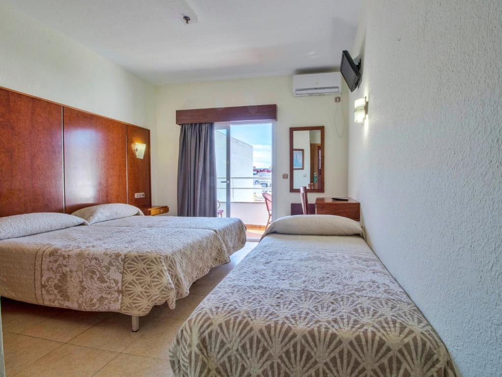 a hotel room with two beds and a balcony at Nch Hotel Torremolinos in Torremolinos