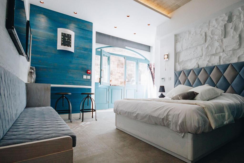 a bedroom with a bed and a blue wall at Valletta Collection - Ordinance Suites in Valletta